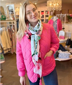 Maxim portant un manteau rose et un foulard de la boutique